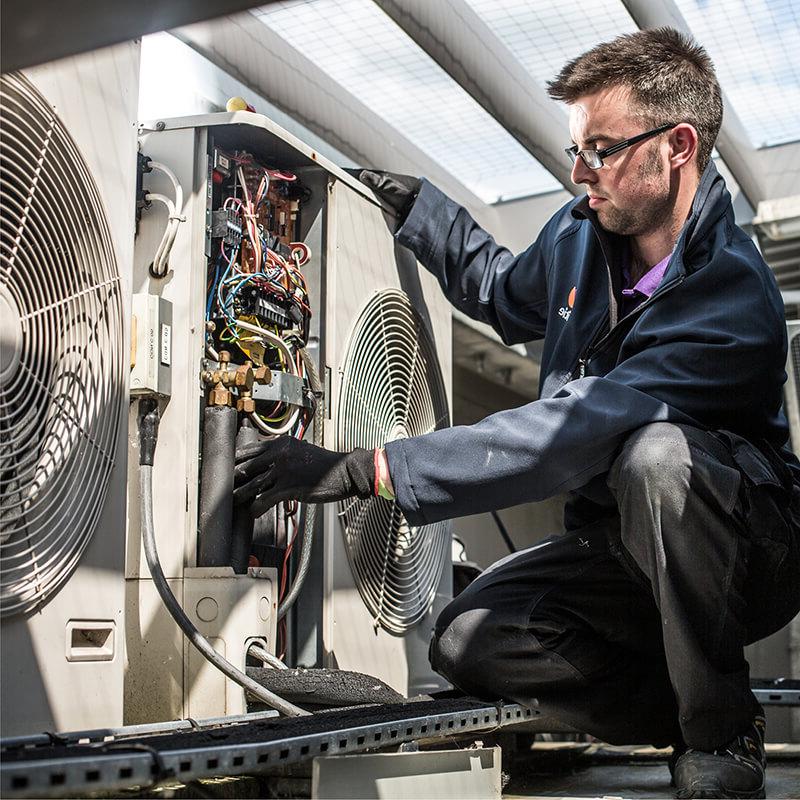 Mitie engineer working on an air con system